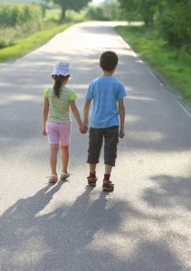 Mindre barn går på en väg och håller handen