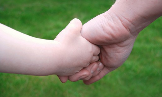 Vuxenhand håller en barnhand