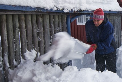 man skottar snö