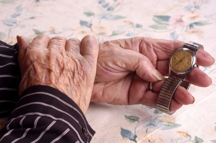 händer, äldre person som håller ett armbandsur