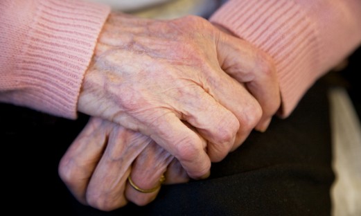 En äldre kvinnas korsade händer