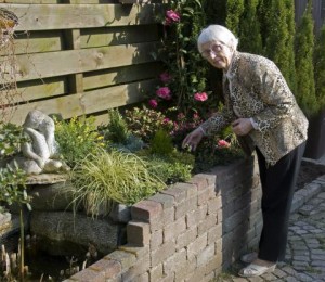 Äldre kvinna i sin trädgård.
