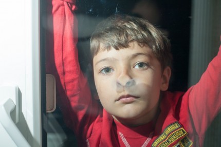 pojke som tittar ut genom ett fönster