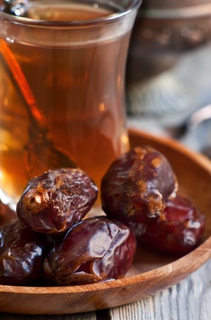 Traditional arabic tea with dry madjool dates and rock sugar nabot. Selective focus.