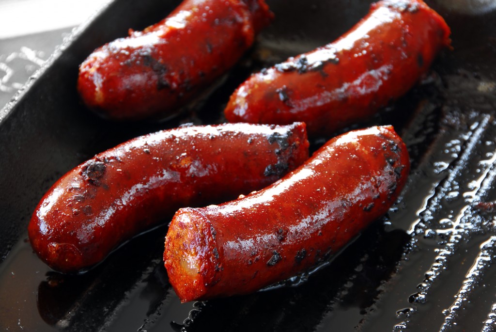 appetizing red roast sausages on frying pan