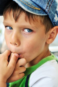 little boy licking his finger