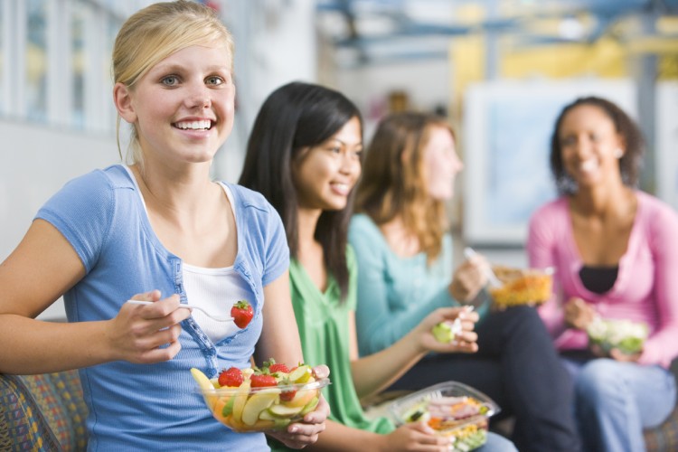 Teenage girls enjoying healthy lunches together