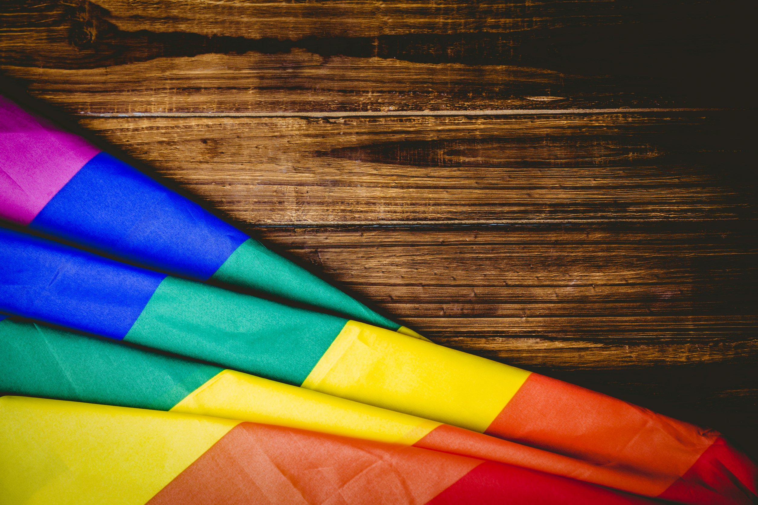 Gay pride flag on wooden table shot in studio