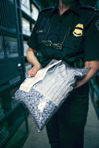 A CBP Officer displays a large bag of seized counterfeit Viagra phamaceuticals.