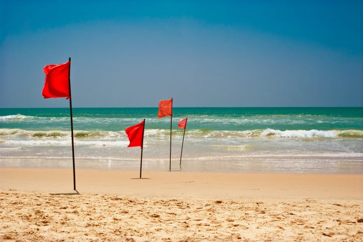 Röda varningsflaggor som varnar för starka vågor.