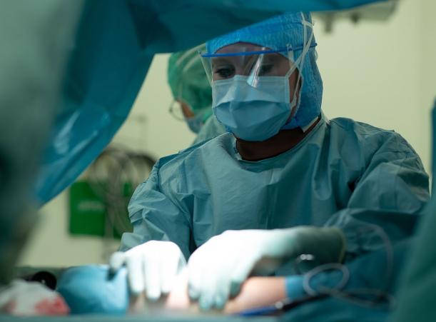 Bilden föreställer Malin Zimmerman klädd i operationskläder när hon utför en operation