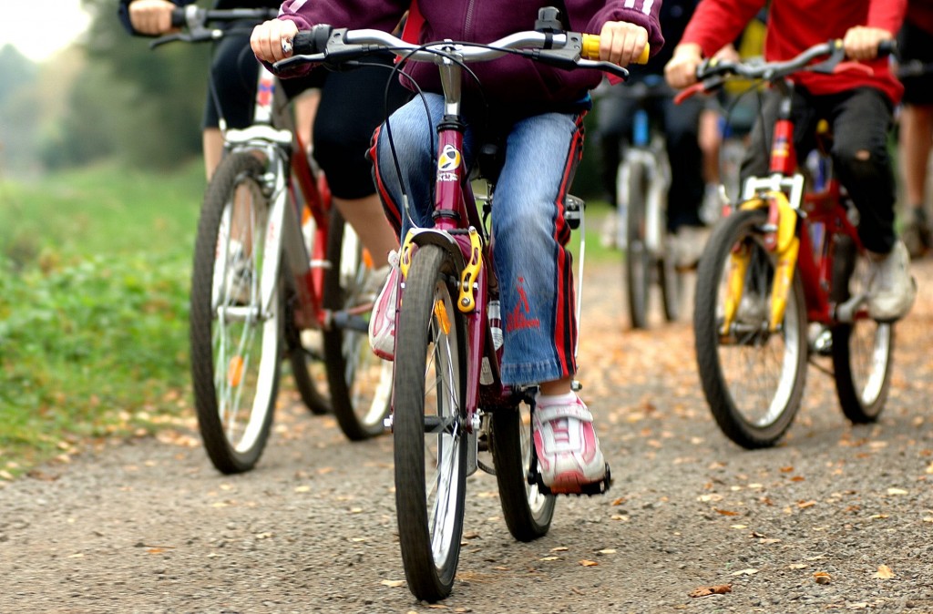 en grupp barns cyklar på en grusväg. Bilden är tagen nerifrån varför bara cyklarna och barnens bens sys på bilden
