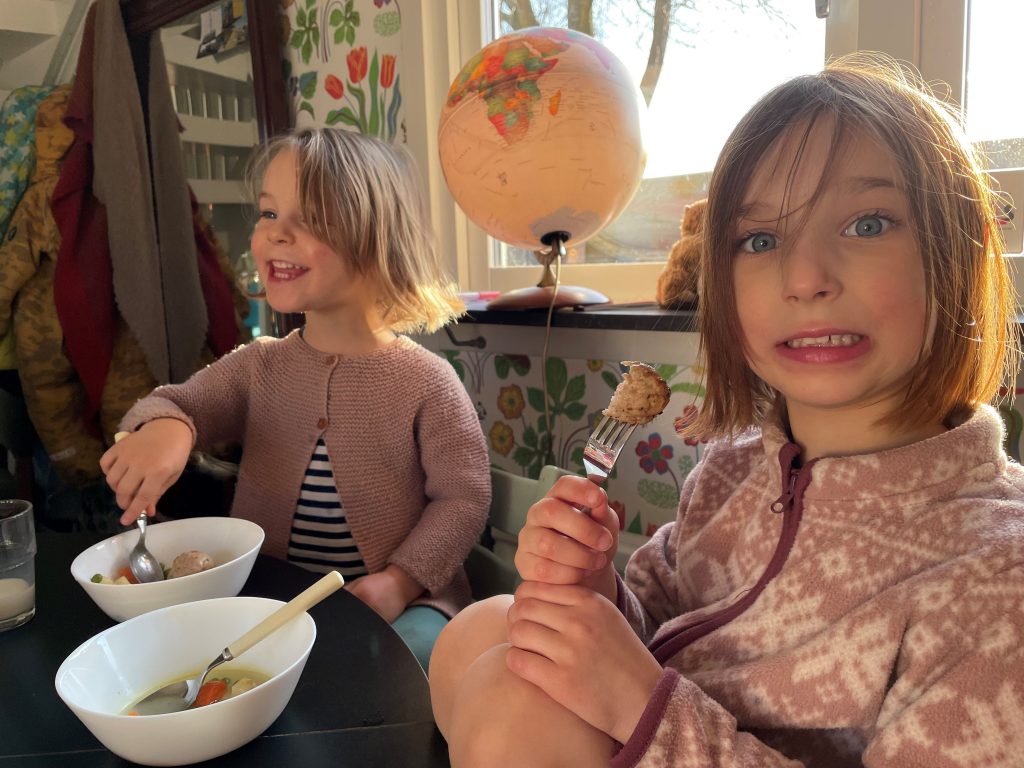Två barn som sitter och äter ur djupa skålar