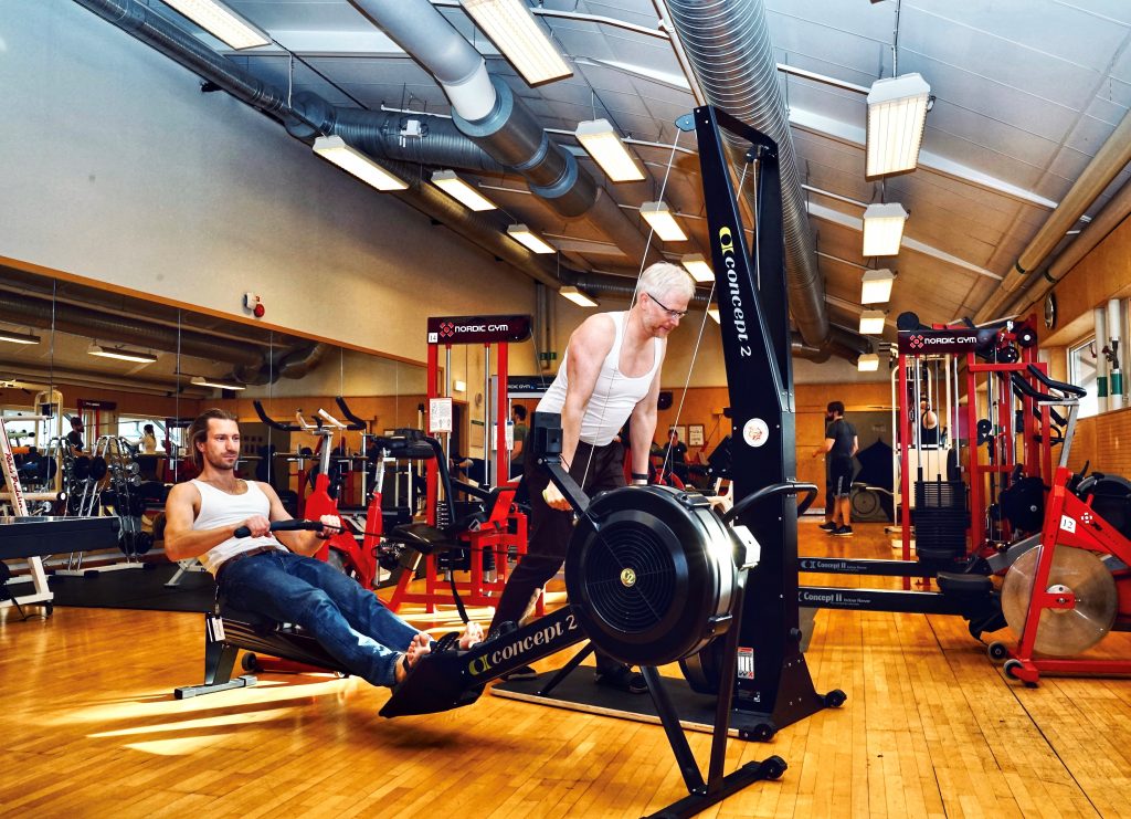 Två män i jeans och linne gymmar.