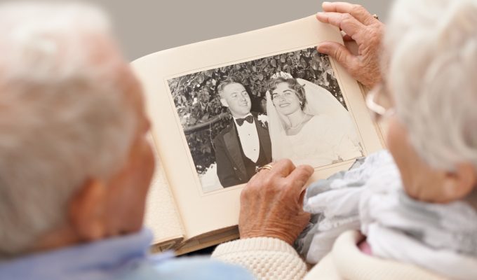 äldre par tittar på bröllopsfoto.