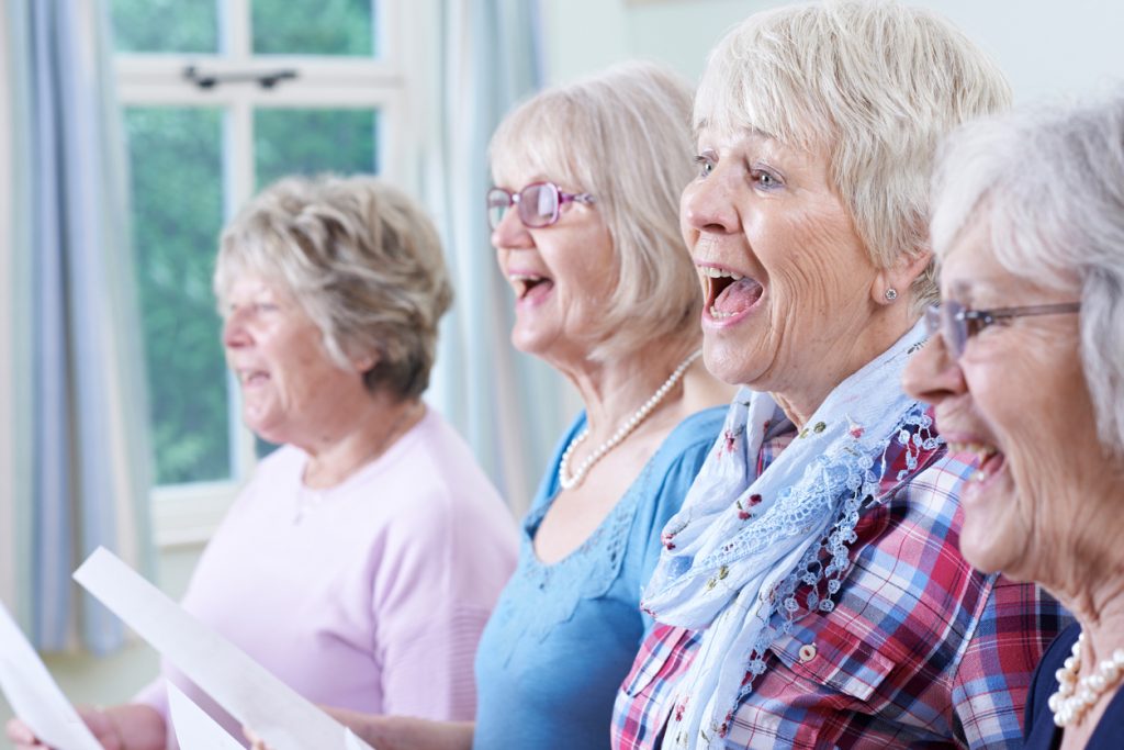fyra äldre kvinnor sjungner i kör