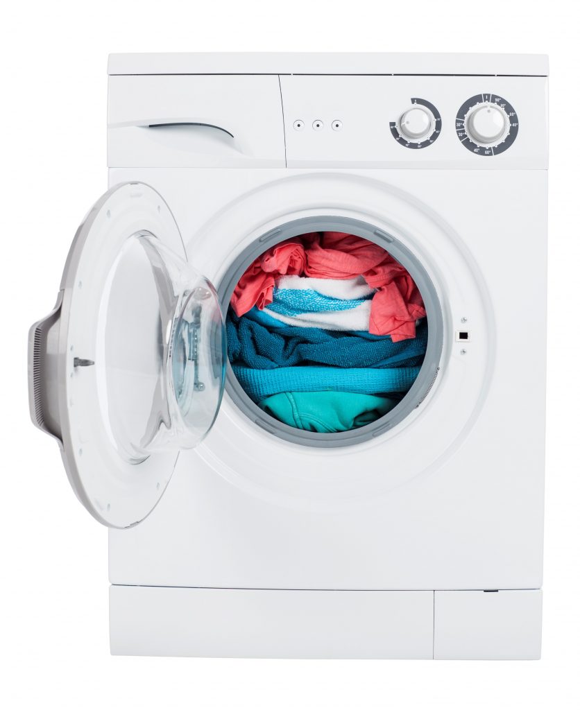 Foto av tvättmaskin med färgglad tvätt i.