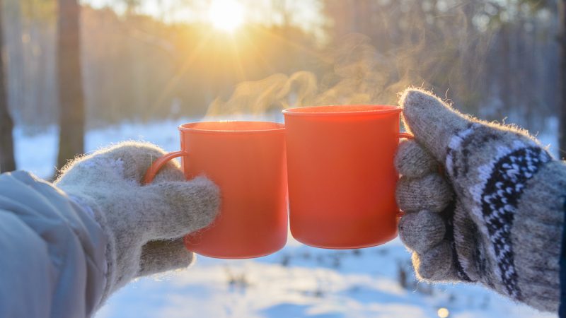 Två kaffekoppar tillsammans i en skål mot snöig bakgrund.
