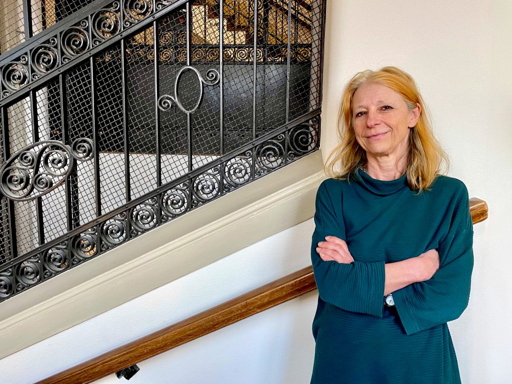 Blond kvinna vid gammal utsirad järntrappa.