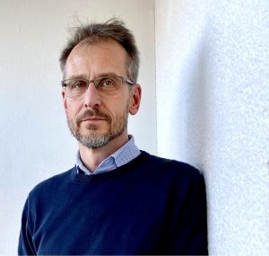 Porträtt av man med mörkblå pullover.