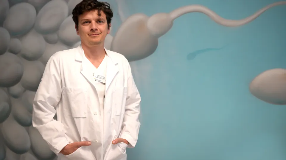 bild på Angel Elenkov framför en tavla föreställande spermier och ägg