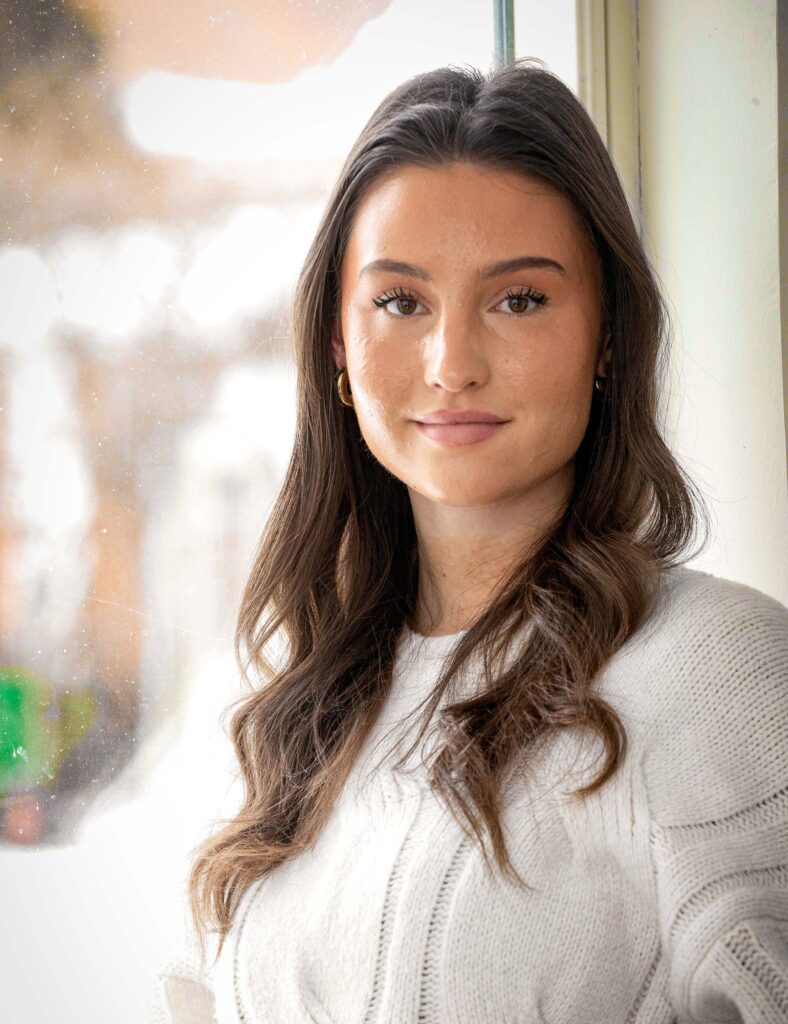 Ung vacker flicka med bruna ögon och långt brunt hår.