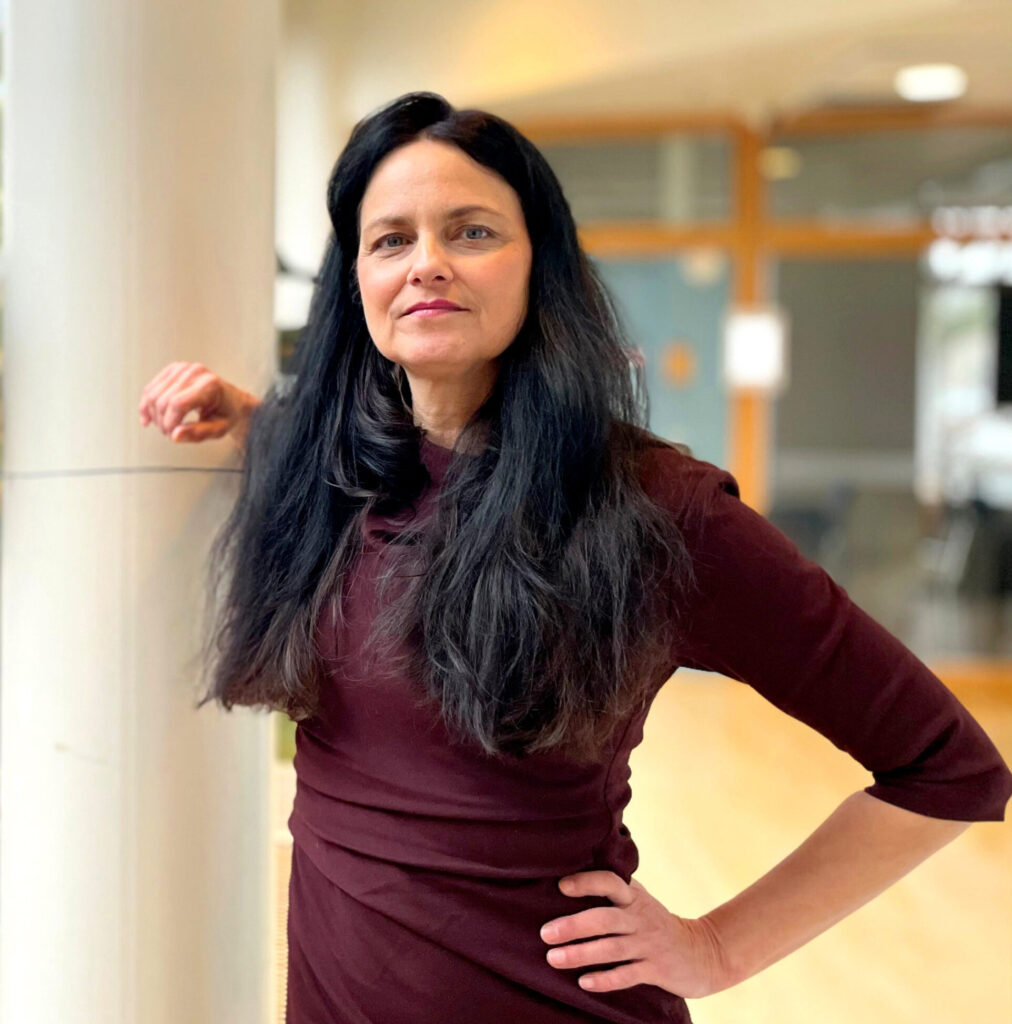 Kvinna med långt mörkt hår i vinröd klänning.