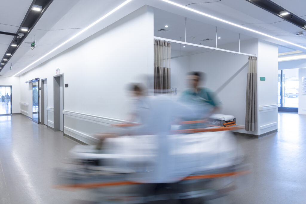 blurrig bild från sjukhuskorridor signalerar brådska vid transport av sjukhussäng