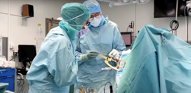 bild från operationssal med två personer i operationskläder och en patient som inte syns bakom alla skynken
